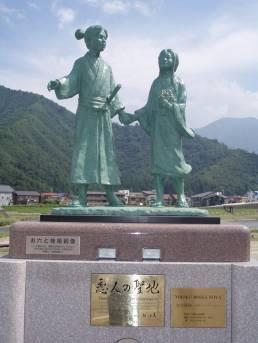 山を背景に建つお六と桂姫の像の写真